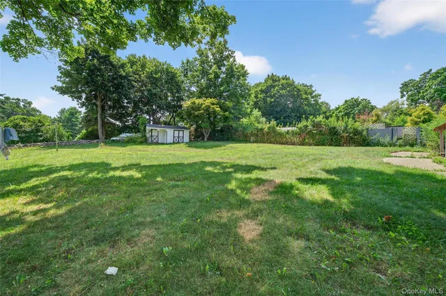a view of house with a big yard and potted plants in front of house