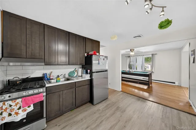 a kitchen that has a lot of cabinets and wooden floor