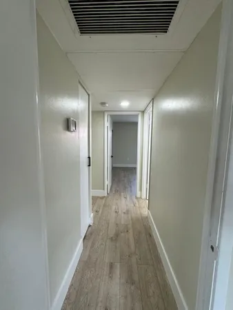 a view of hallway with wooden floor