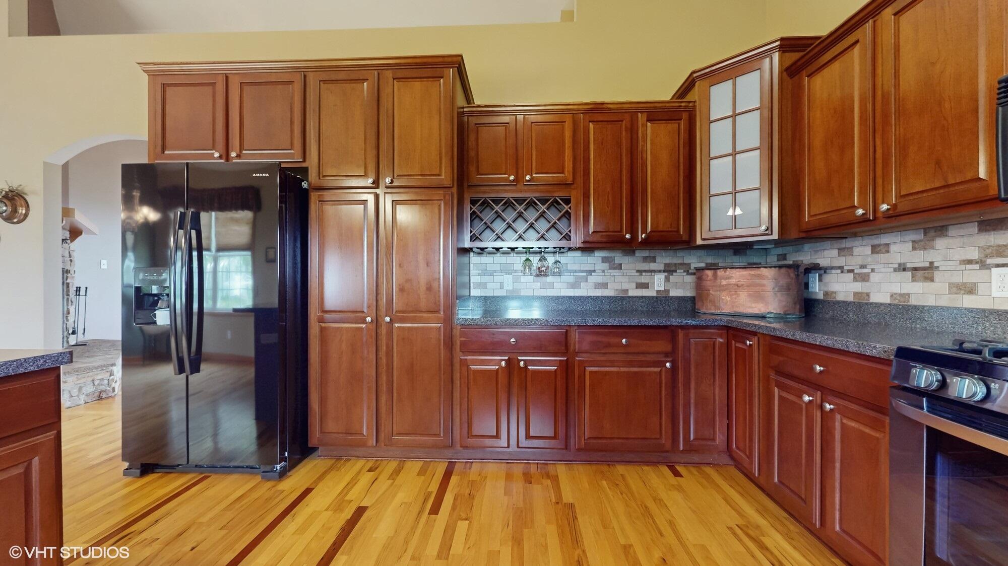 14486 County Road 700 West Demotte, IN 46310 - Photo 8 of 26 a kitchen with stainless steel appliances granite countertop wooden cabinets a refrigerator and a sink