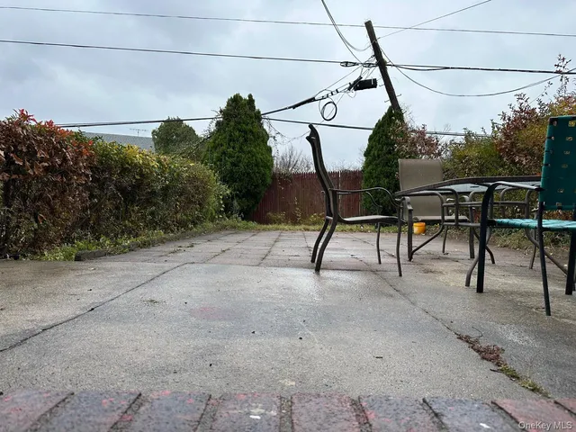 a view of a chairs and table in the backyard