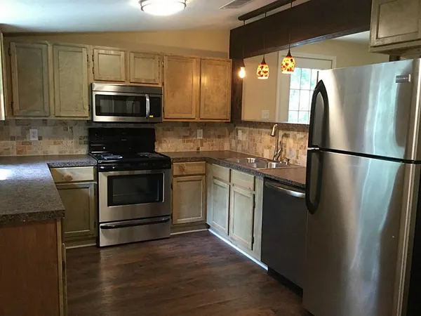 a kitchen with stainless steel appliances a refrigerator stove and microwave
