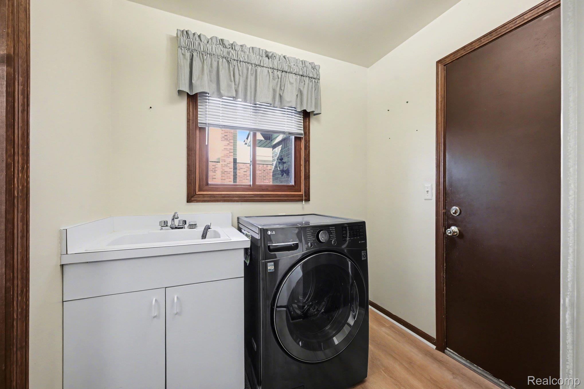 33593 Curtis Road Livonia, MI 48152 - Photo 24 of 30 Laundry room with washer / dryer, light wood finished floors, and cabinet space