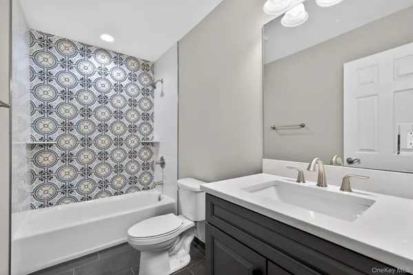 a bathroom with a sink toilet and a mirror