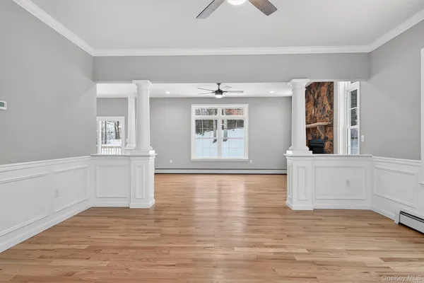 a view of an empty room with window and wooden floor