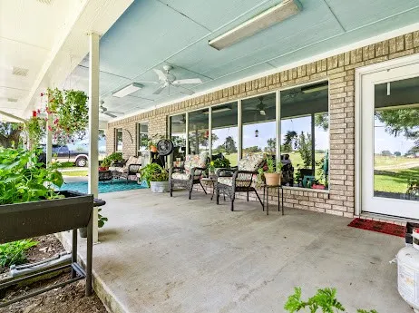 a view of a porch with chairs and potted plants