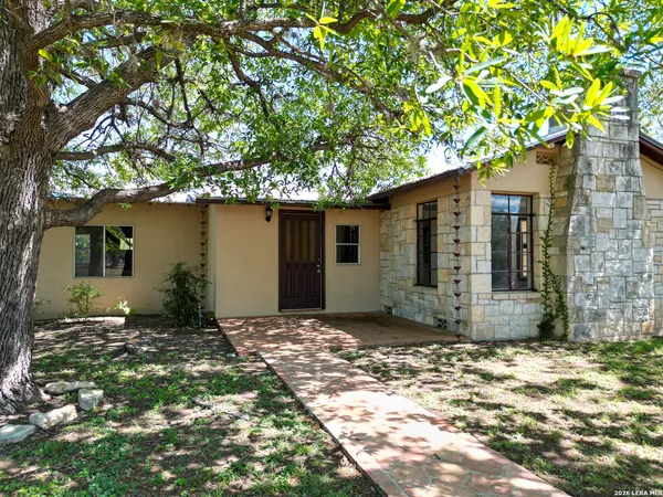 a view of a house with a tree in the yard