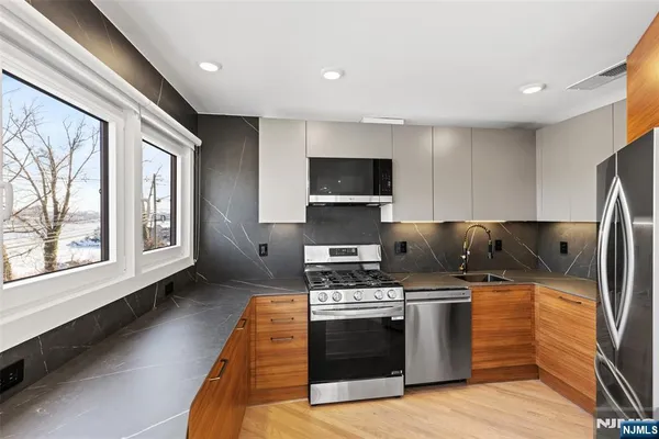 a kitchen with stainless steel appliances a stove a sink and a microwave