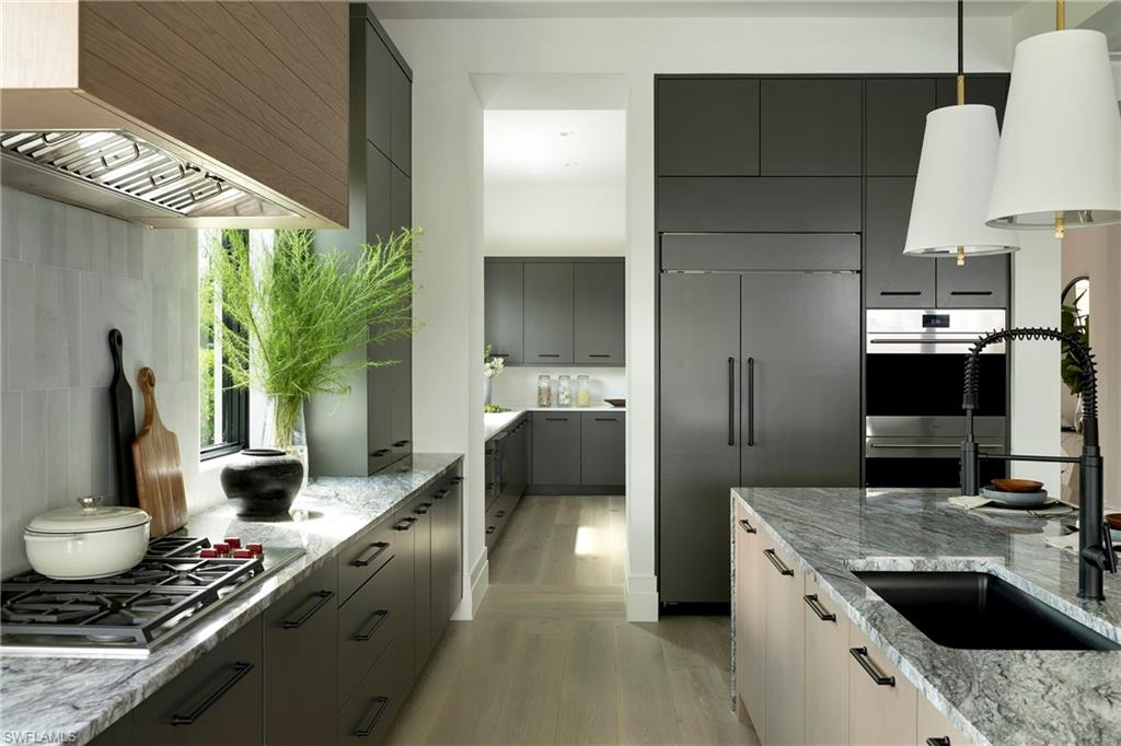 6704 Newport Road Naples, FL 34109 - Photo 11 of 47 a kitchen with a stove a sink and a refrigerator