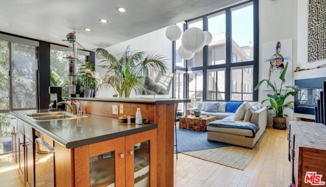 a living room with furniture kitchen view and large windows