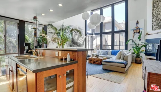 a living room with furniture kitchen view and large windows