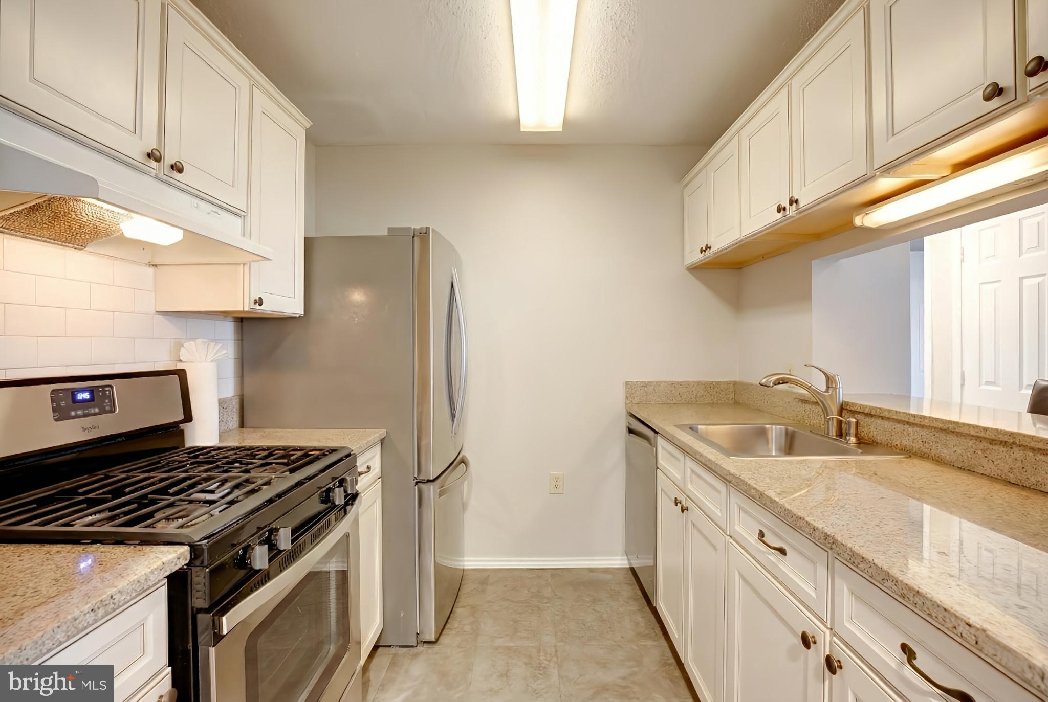 20950 Timber Ridge Terrace, Unit 202 Ashburn, VA 20147 - Photo 12 of 22 a kitchen with stainless steel appliances granite countertop a sink stove and cabinets