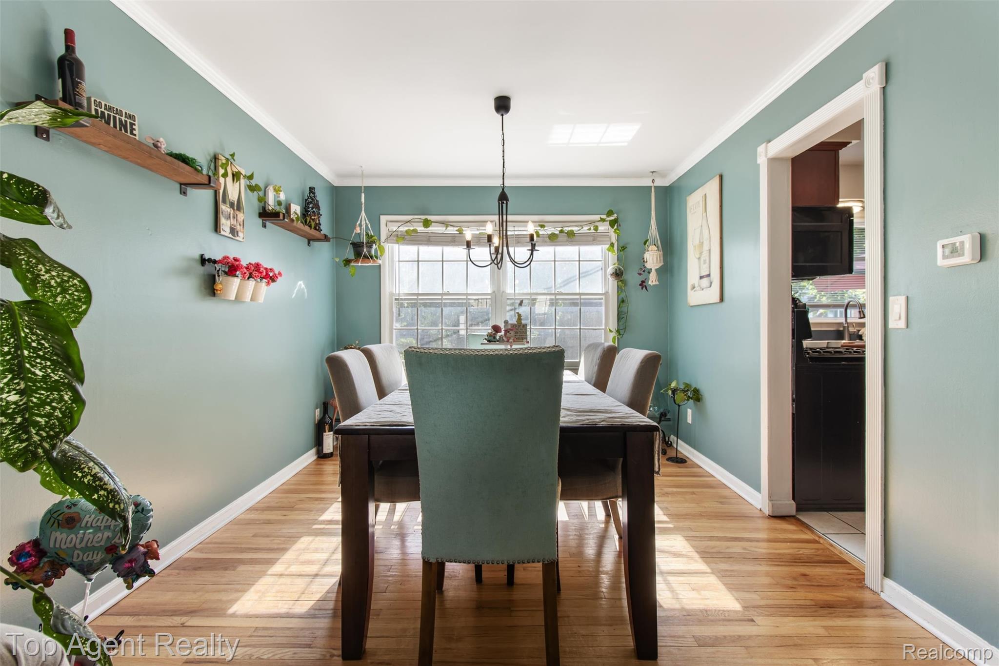32341 Woody Road Fraser, MI 48026 - Photo 10 of 47 Dining area featuring wood-finish flooring, a central window, crown molding, and a skylight
