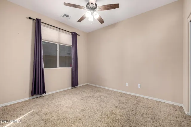 an empty room with a window and a fan