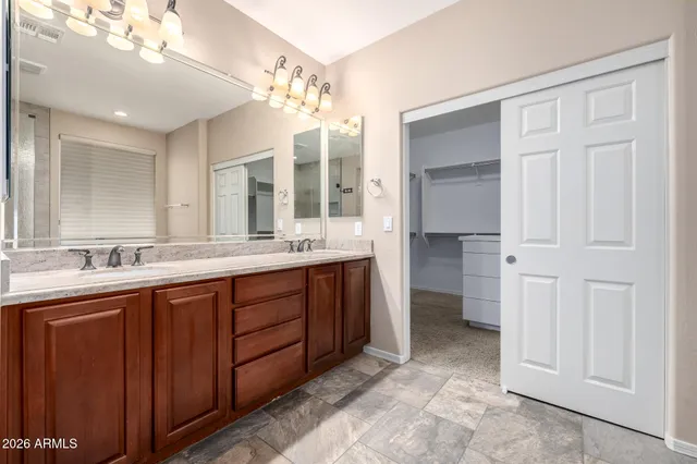 a spacious bathroom with a double vanity sink a mirror and a shower