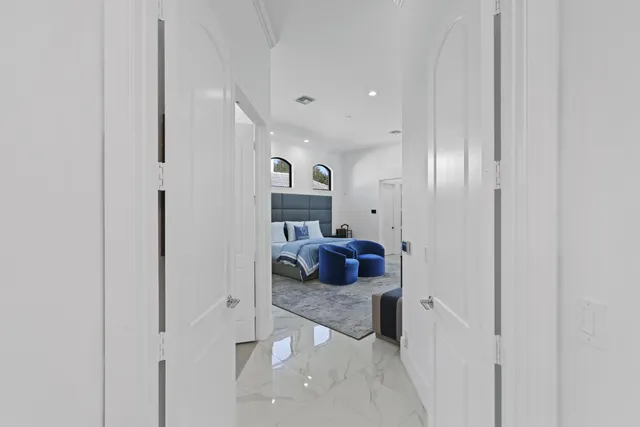 a front view of a house with a yard and palm trees