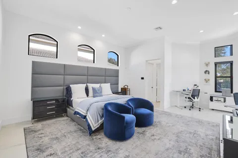 a bedroom with a bed and a large window