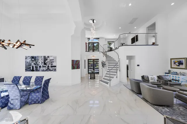 a living room with furniture a flat screen tv and a floor to ceiling window