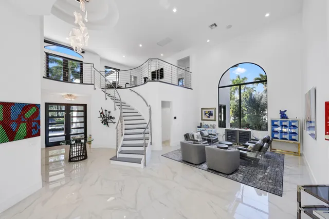 a living room with furniture a flat screen tv and a floor to ceiling window