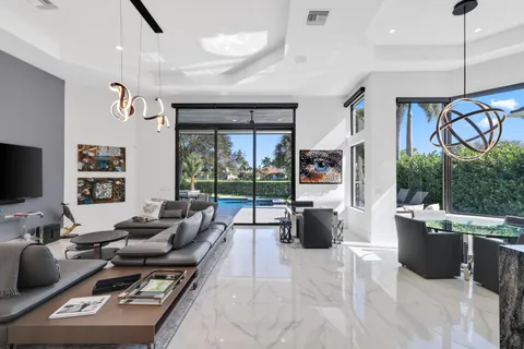 a living room with furniture a flat screen tv and a floor to ceiling window
