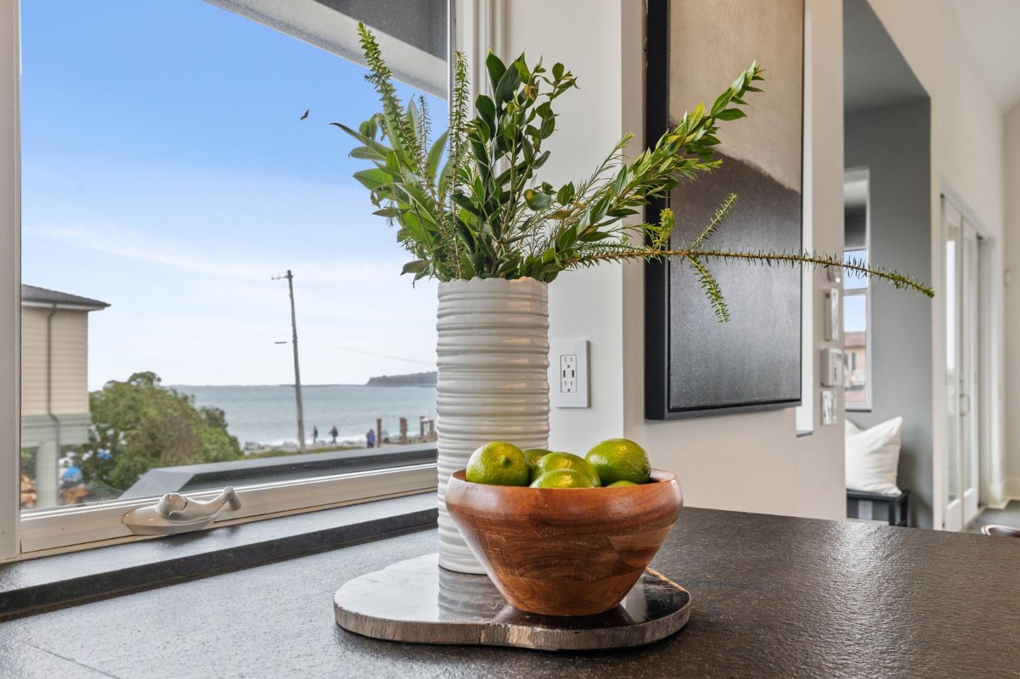 100 Coronado Avenue Half Moon Bay, CA 94019 - Photo 18 of 64 a vase of flowers sitting on a table with a potted plant