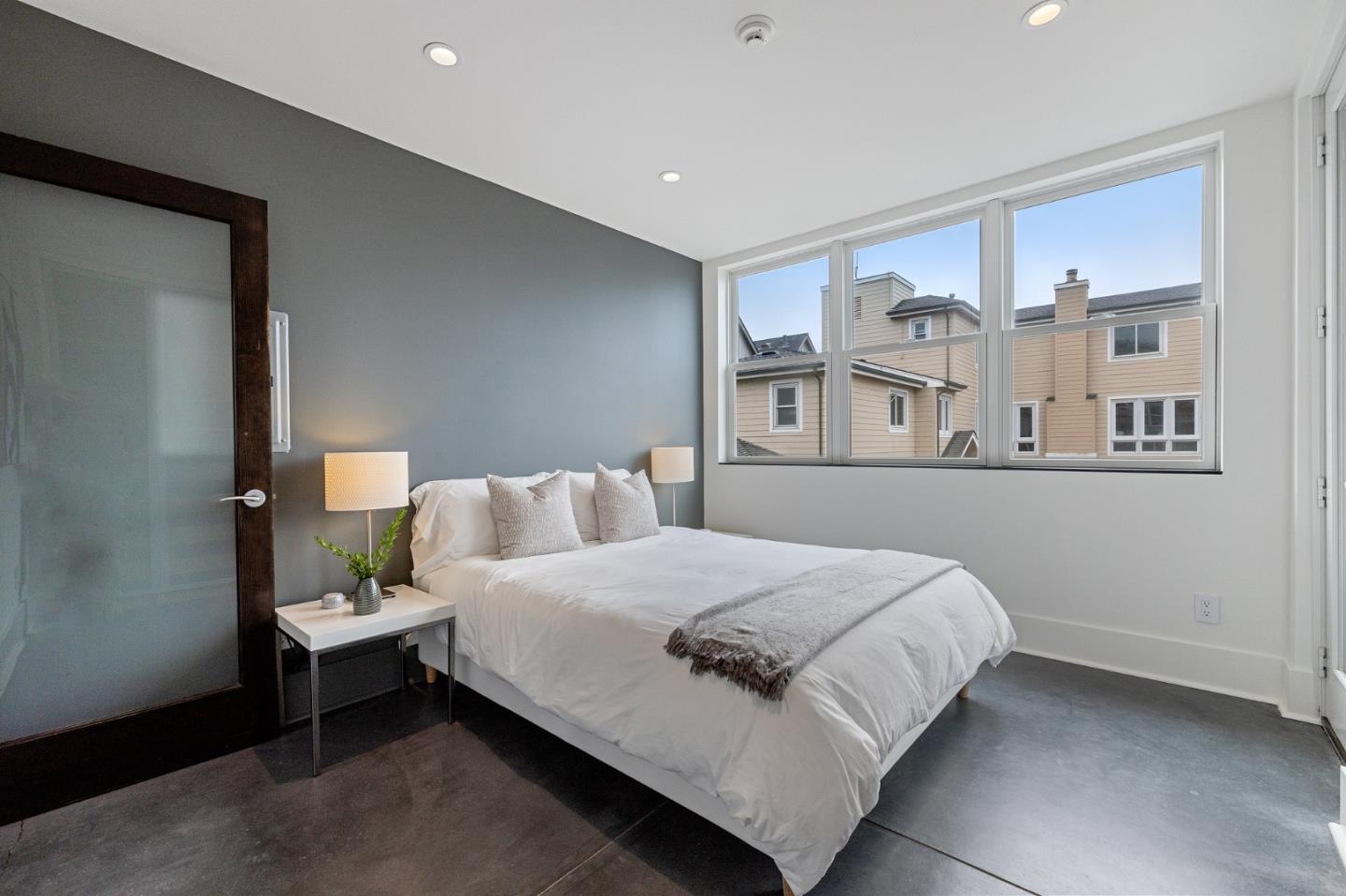 100 Coronado Avenue Half Moon Bay, CA 94019 - Photo 29 of 64 a bedroom with a bed lamp and a window