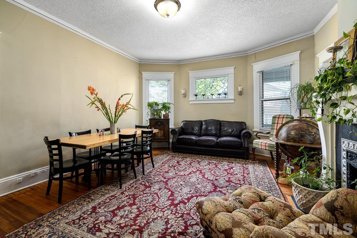 415 New Bern Avenue Raleigh, NC 27601 - Photo 18 of 54 a living room with furniture a dining table and a potted plant