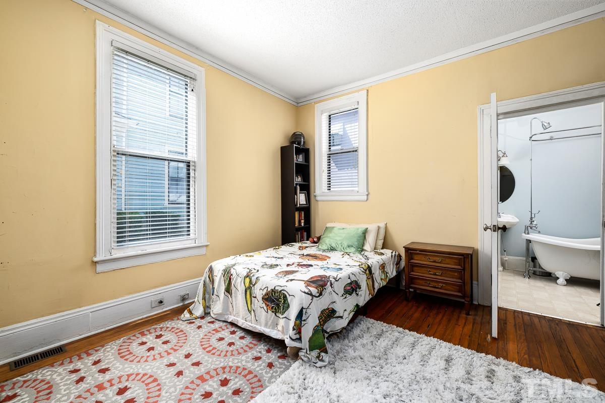 415 New Bern Avenue Raleigh, NC 27601 - Photo 21 of 54 a bedroom with a bed and wooden floor