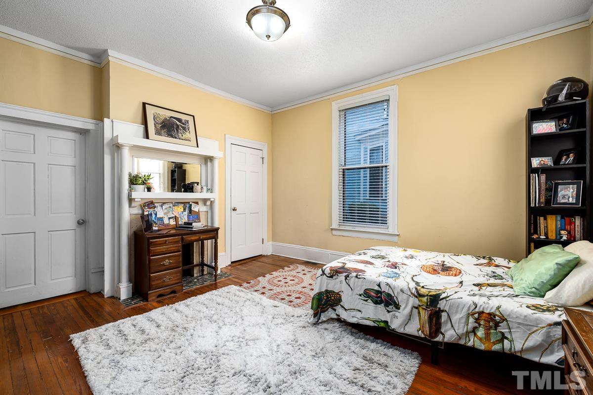 415 New Bern Avenue Raleigh, NC 27601 - Photo 22 of 54 a bedroom with a bed and wooden floor