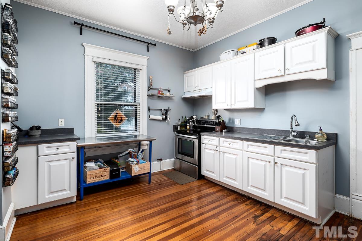 415 New Bern Avenue Raleigh, NC 27601 - Photo 25 of 54 a kitchen with stainless steel appliances granite countertop a stove and cabinets
