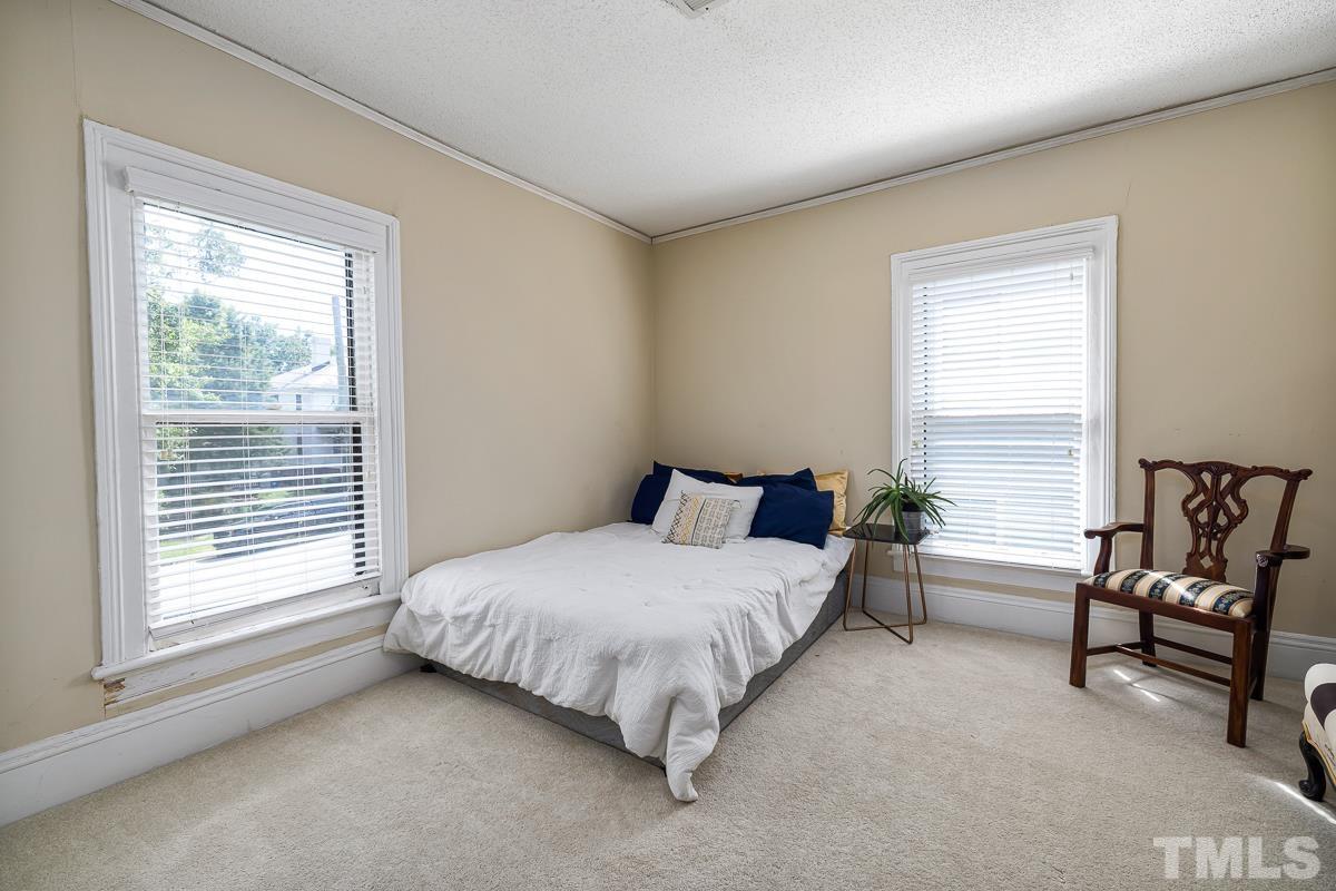 415 New Bern Avenue Raleigh, NC 27601 - Photo 32 of 54 a spacious bedroom with a bed chair and two windows