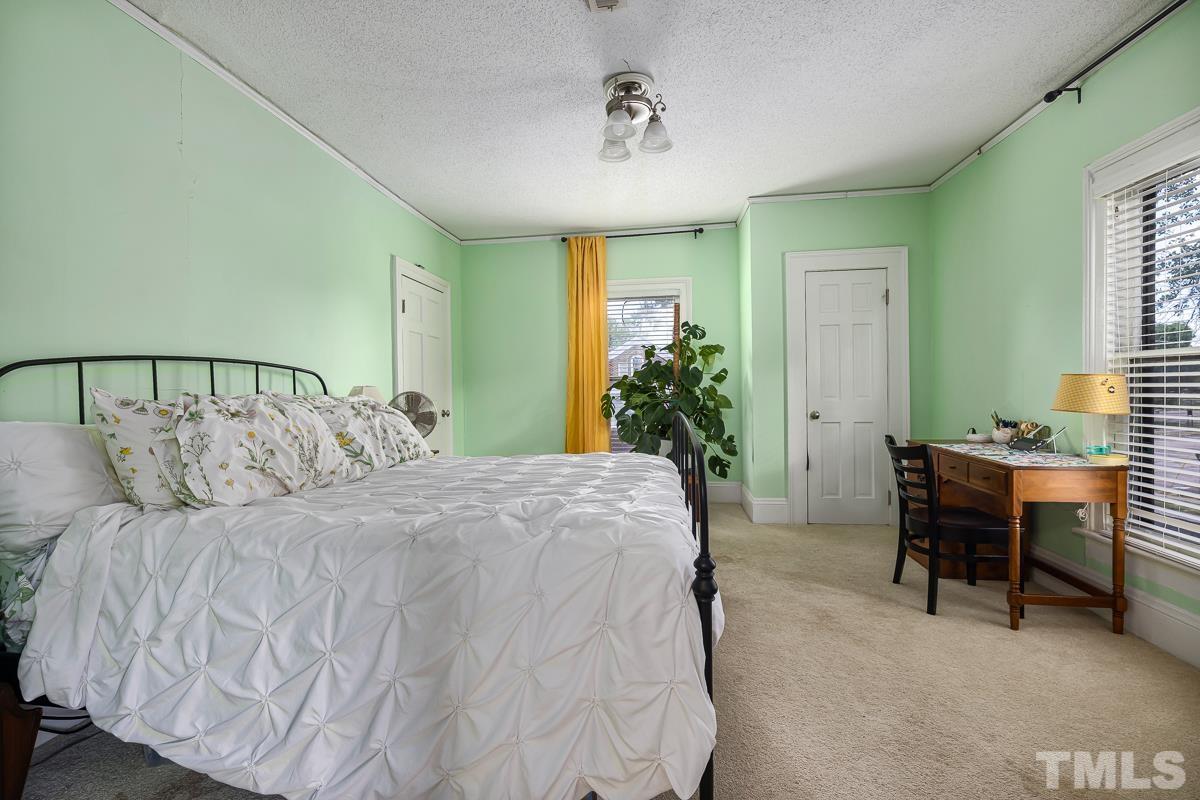 415 New Bern Avenue Raleigh, NC 27601 - Photo 33 of 54 a large bed sitting in a bedroom next to a window and a chandelier
