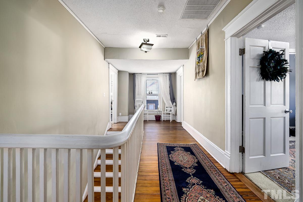 415 New Bern Avenue Raleigh, NC 27601 - Photo 38 of 54 a view of a hallway with wooden floor and staircase