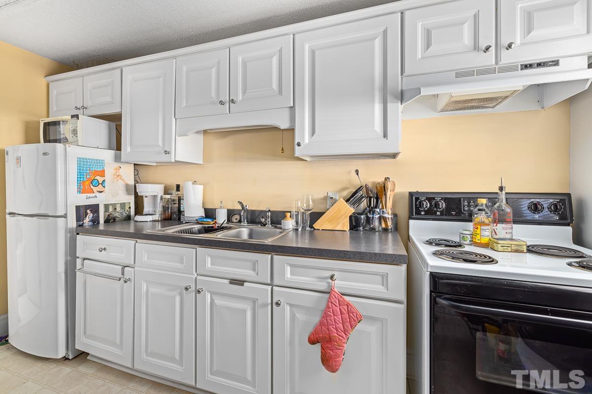 415 New Bern Avenue Raleigh, NC 27601 - Photo 49 of 54 a kitchen with white cabinets and white appliances