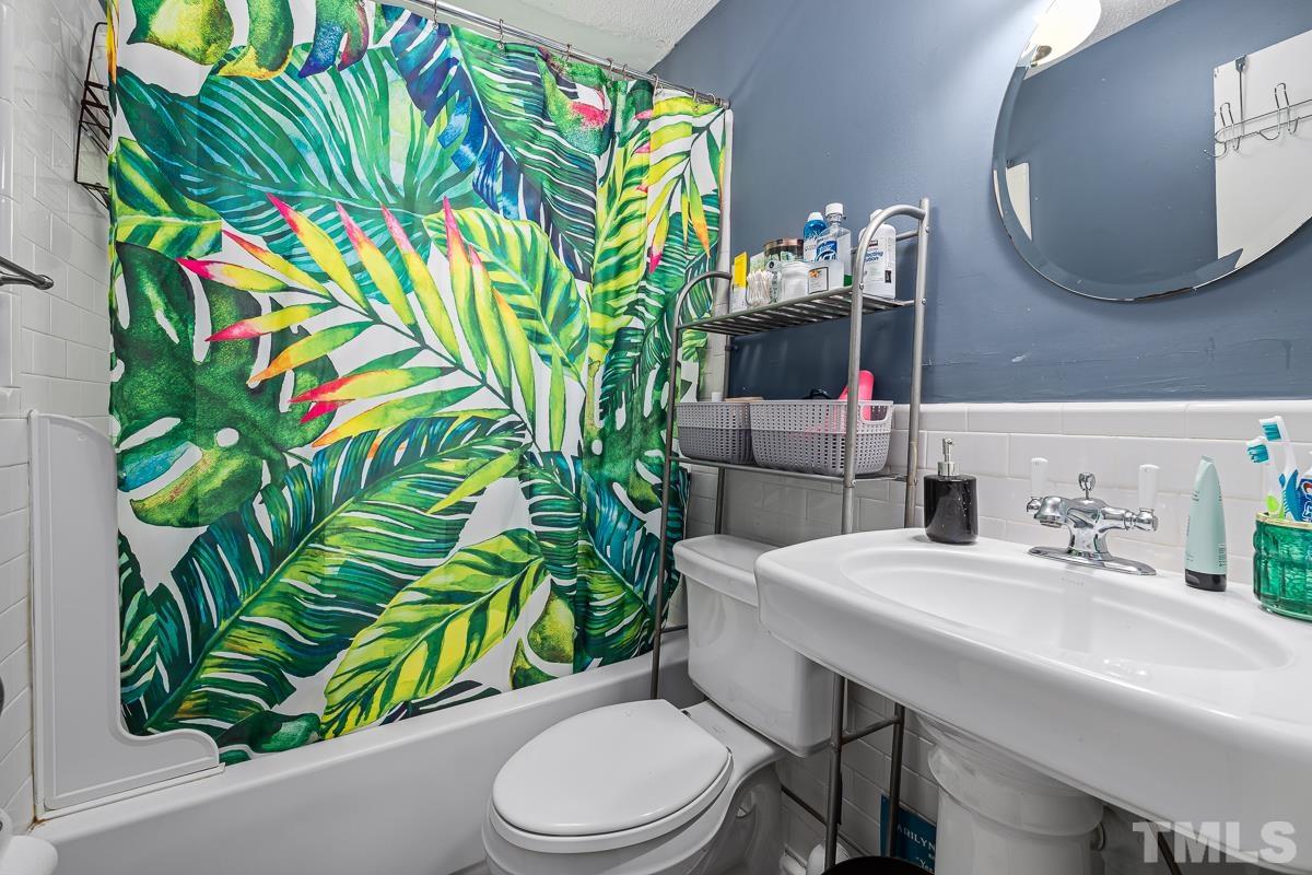 415 New Bern Avenue Raleigh, NC 27601 - Photo 51 of 54 a bathroom with a sink a toilet and mirror
