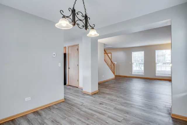 a view of empty room with wooden floor and window