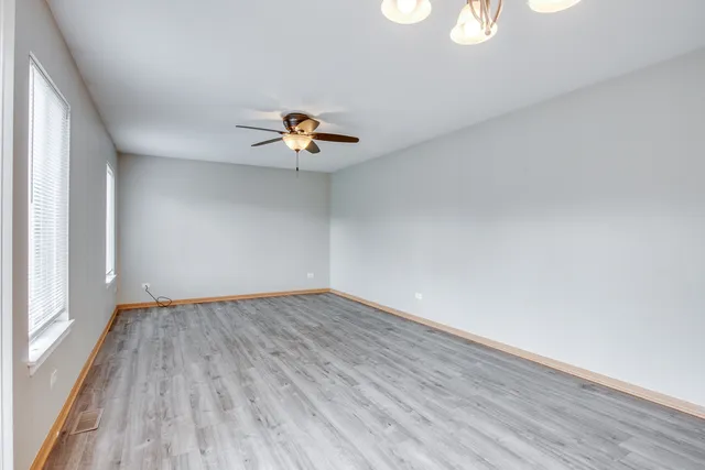 an empty room with wooden floor and window