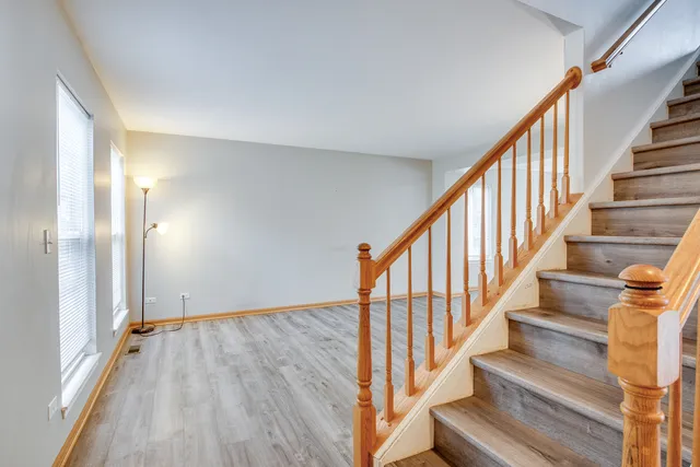 a view of staircase with wooden floor and white walls