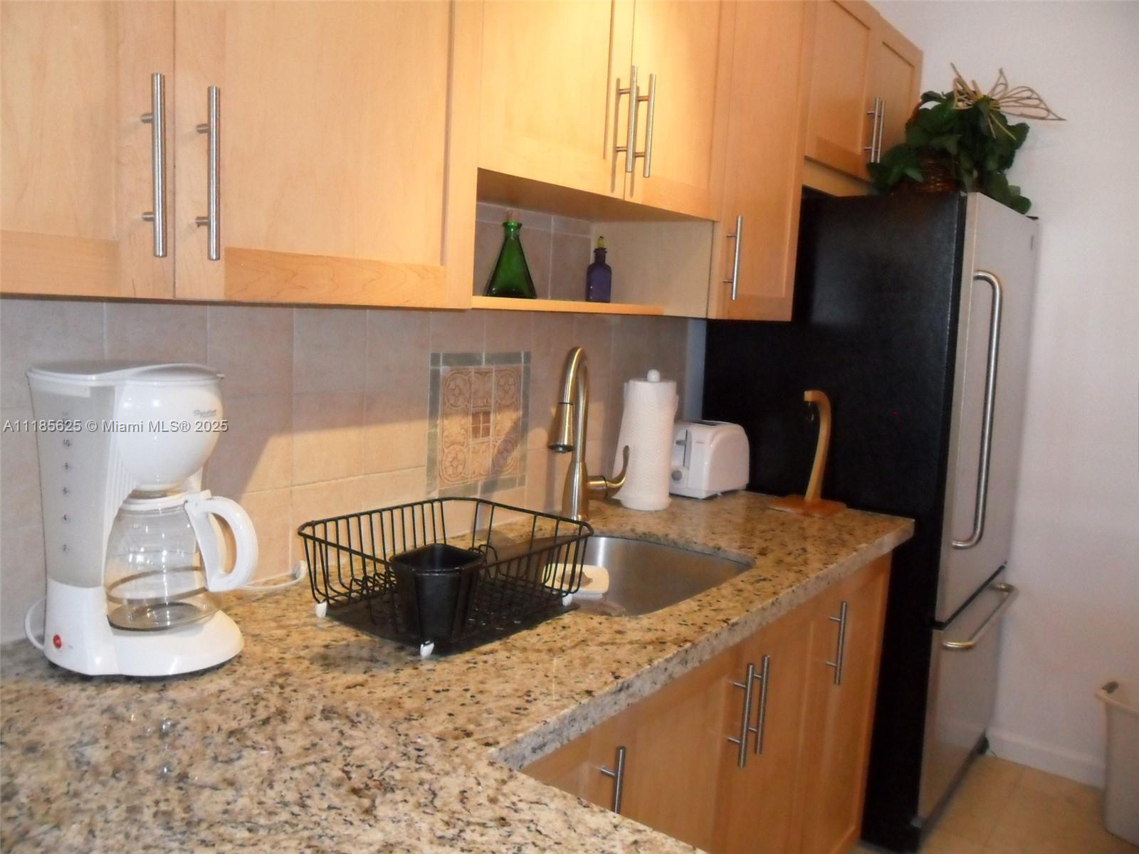 100 Lincoln Road, Unit 1243 Miami Beach, FL 33139 - Photo 4 of 29 a kitchen with a sink and a refrigerator