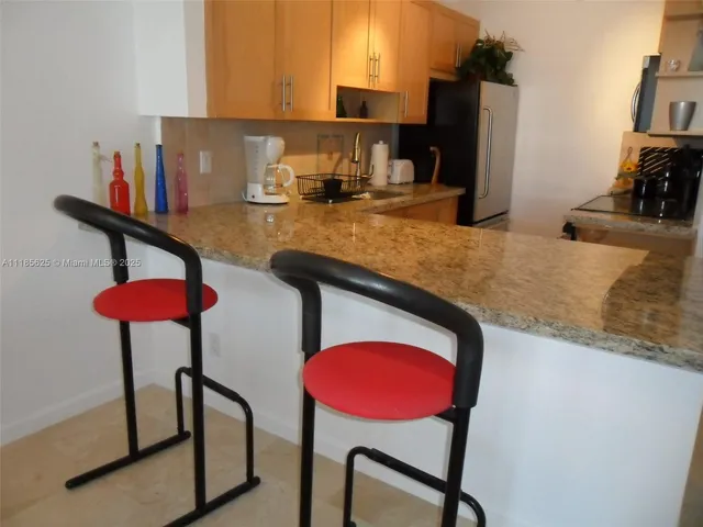 a kitchen with stainless steel appliances granite countertop a sink cabinets and a refrigerator