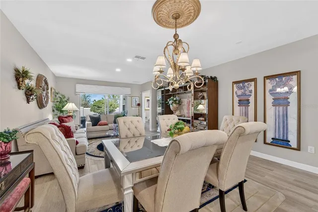 a view of a dining room with furniture a chandelier and wooden floor