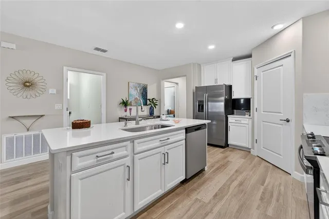 a kitchen with white cabinets and stainless steel appliances