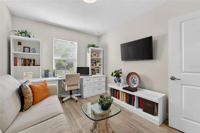 a living room with furniture a flat screen tv and a window