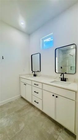 a bathroom with double sink and a mirror
