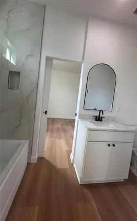 a bathroom with a sink a mirror and a bathtub