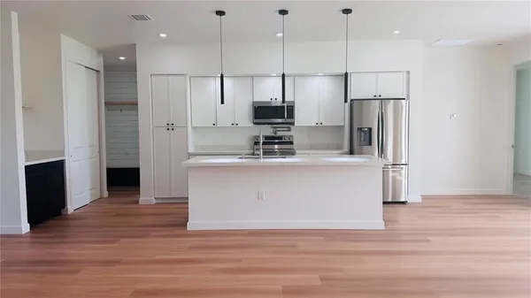 a view of kitchen with stainless steel appliances refrigerator oven and cabinets