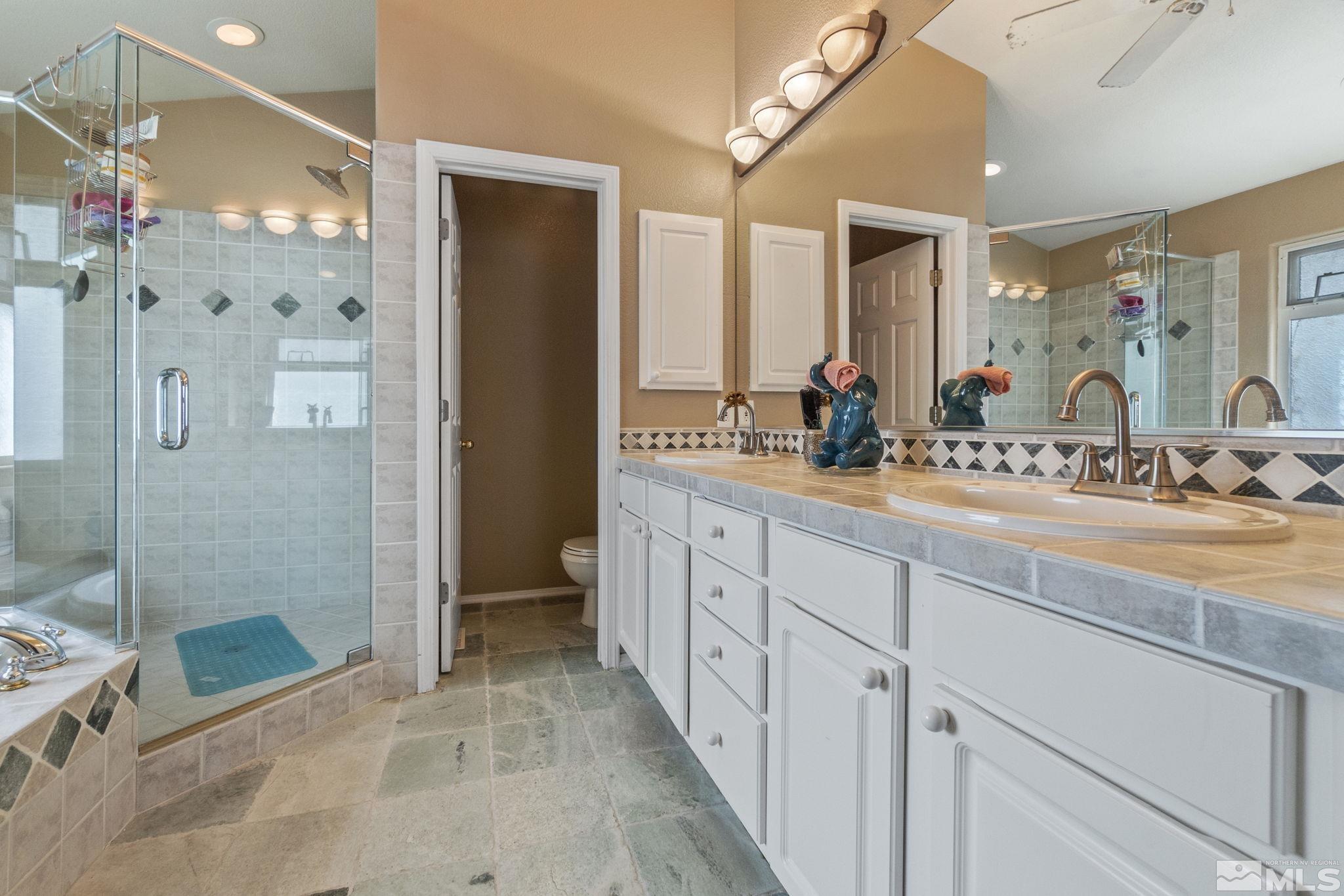6075 Sunrise Meadows Loop Reno, NV 89519 - Photo 17 of 38 a spacious bathroom with double vanity and a mirror