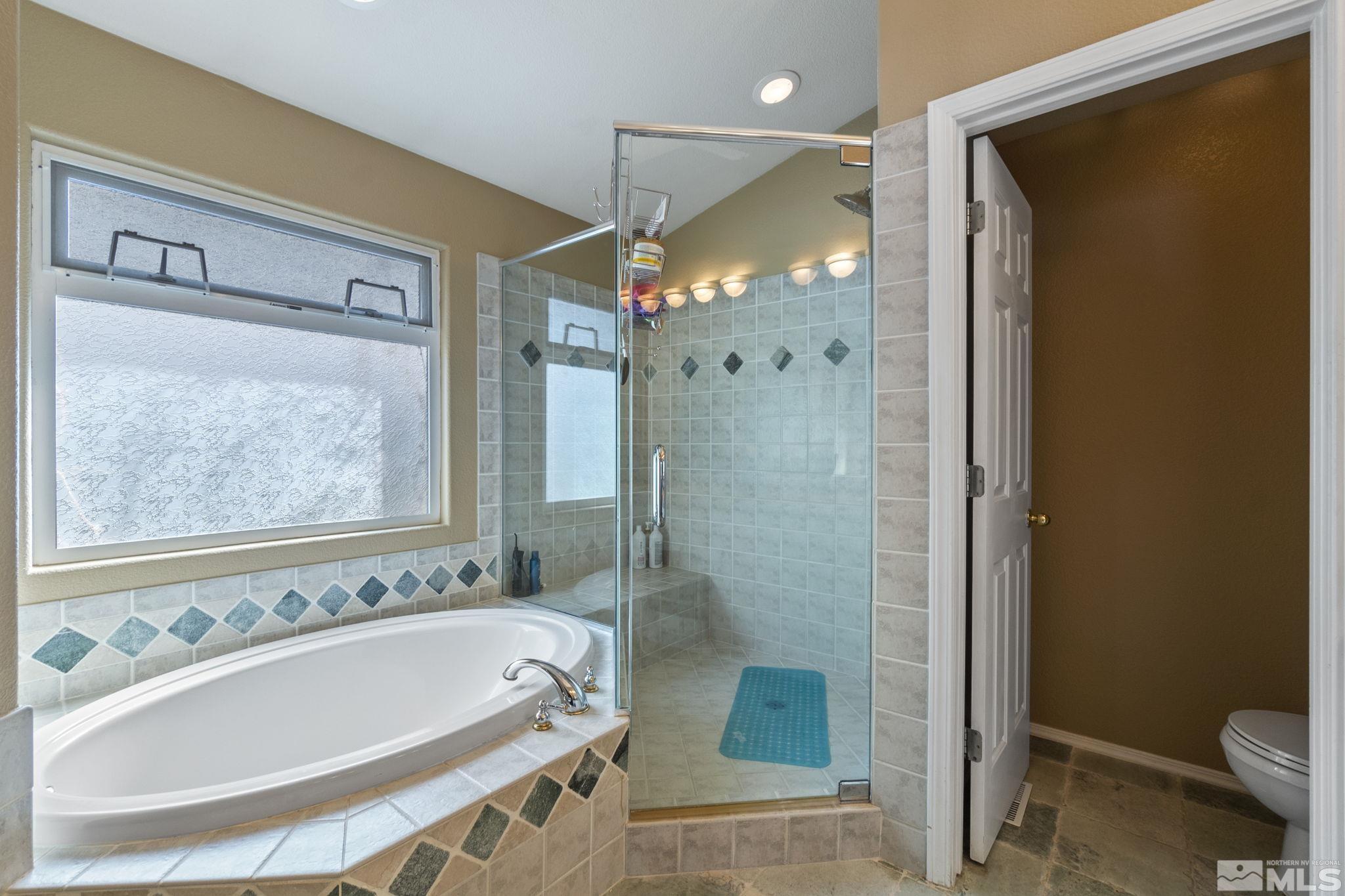 6075 Sunrise Meadows Loop Reno, NV 89519 - Photo 18 of 38 a bathroom with a tub a sink and a large mirror