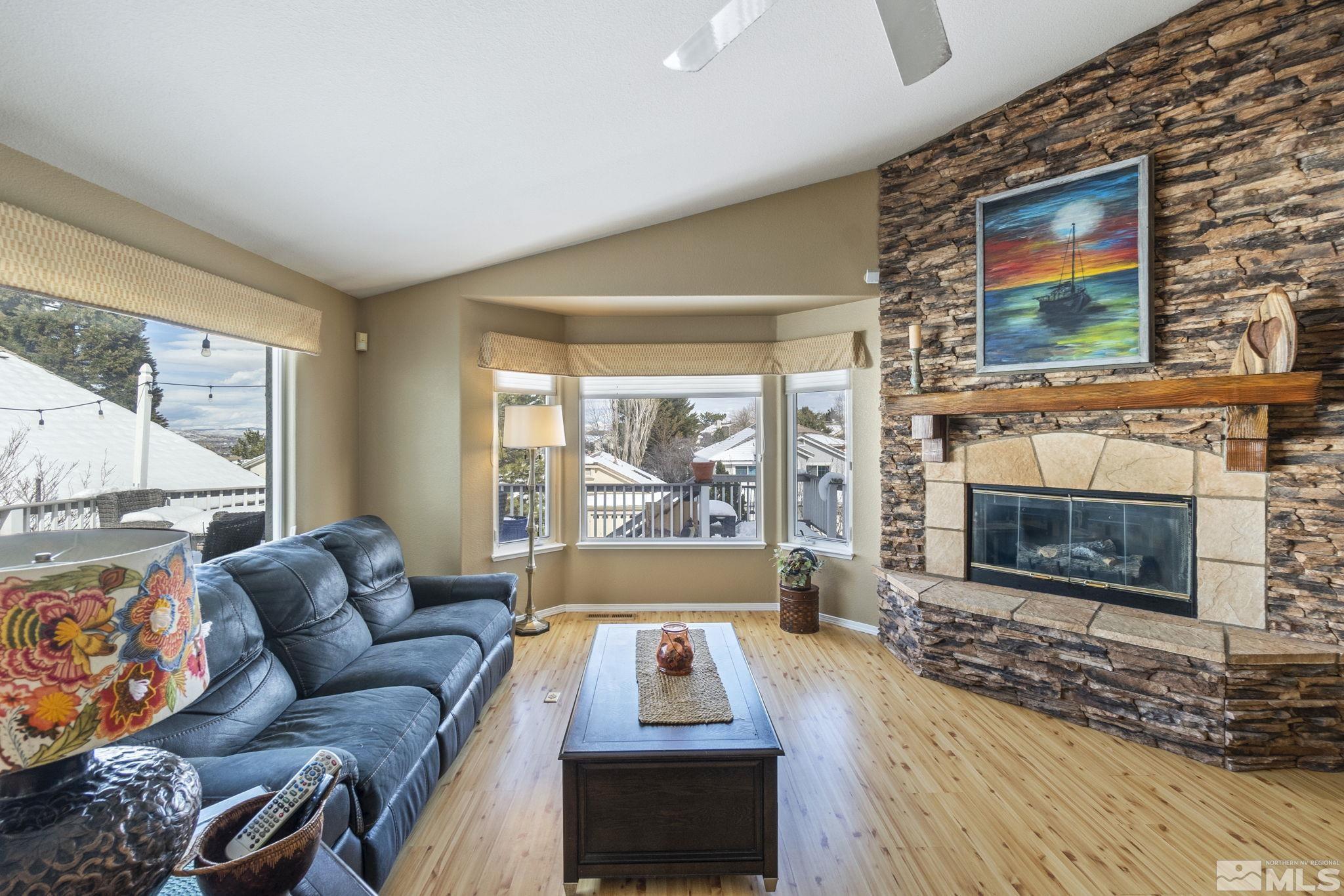 6075 Sunrise Meadows Loop Reno, NV 89519 - Photo 34 of 38 a living room with furniture a flat screen tv and a fireplace