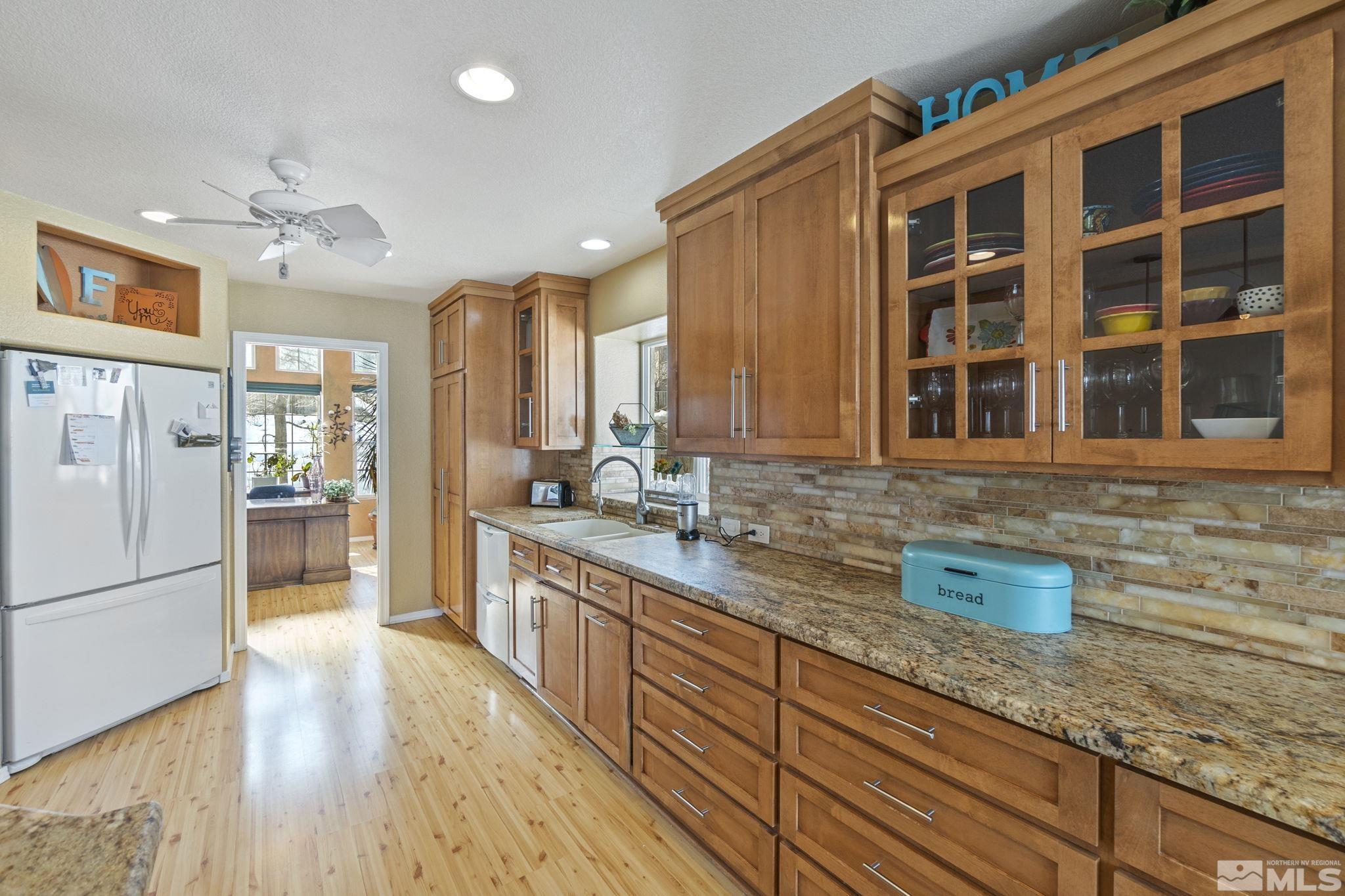 6075 Sunrise Meadows Loop Reno, NV 89519 - Photo 5 of 38 a kitchen with stainless steel appliances granite countertop a refrigerator a sink dishwasher a oven with wooden cabinets and floor